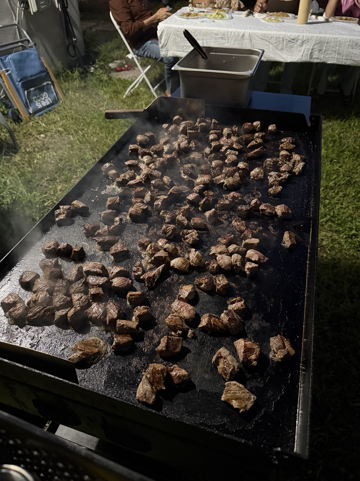 Bite-sized steak pieces cooking on the hibachi grill